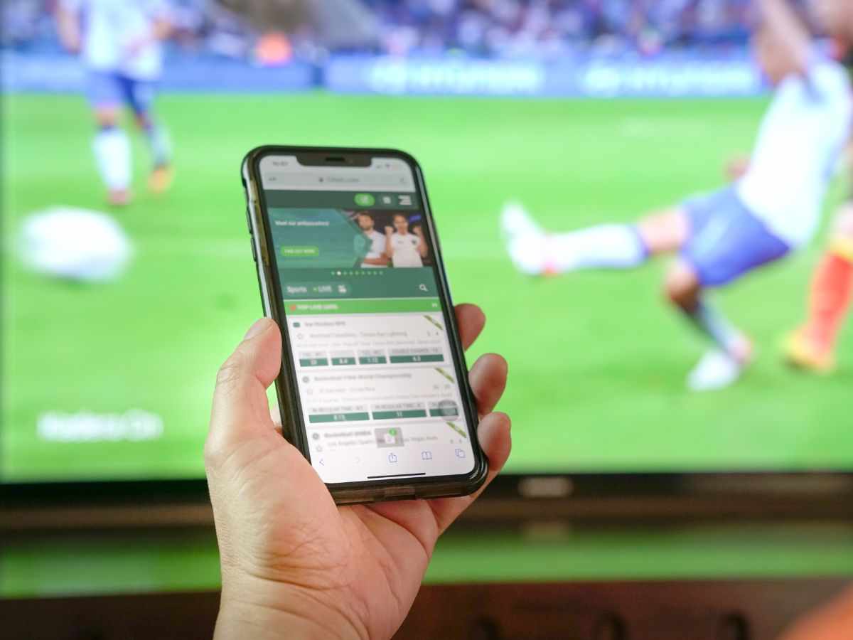 persona che segue i risultati live sul cellulare